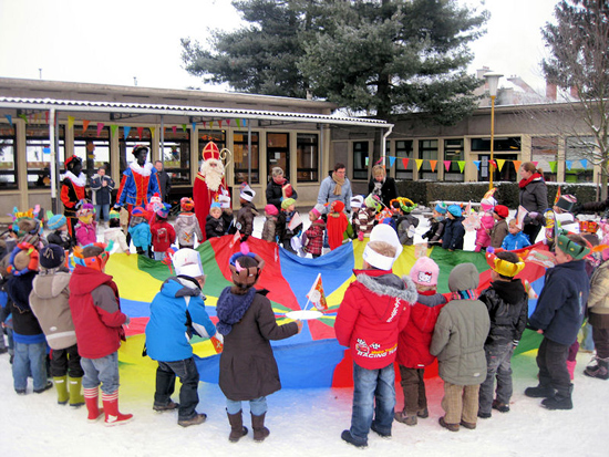 Op de speelplaats van de Mercatorschool stonden kinderen al te wachten met een valscherm. De Sint vond dat zeker tof.